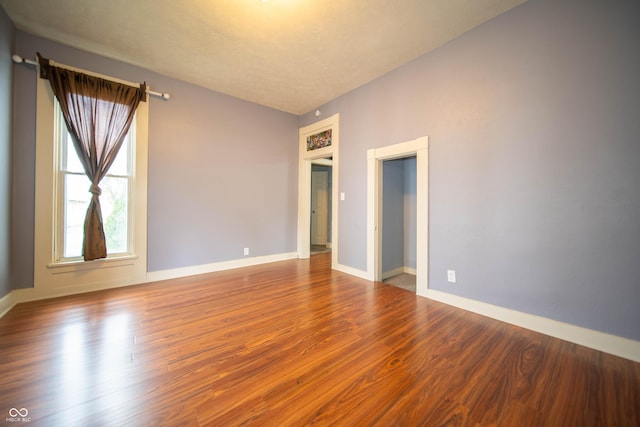 empty room with baseboards and wood finished floors