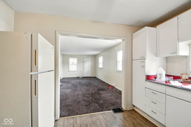 1235 N Grant Ave, Indianapolis, IN 46201 - kitchen with freestanding refrigerator, wood finished floors, and white cabinetry