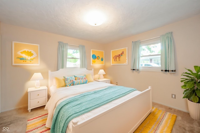 bedroom with light colored carpet and baseboards