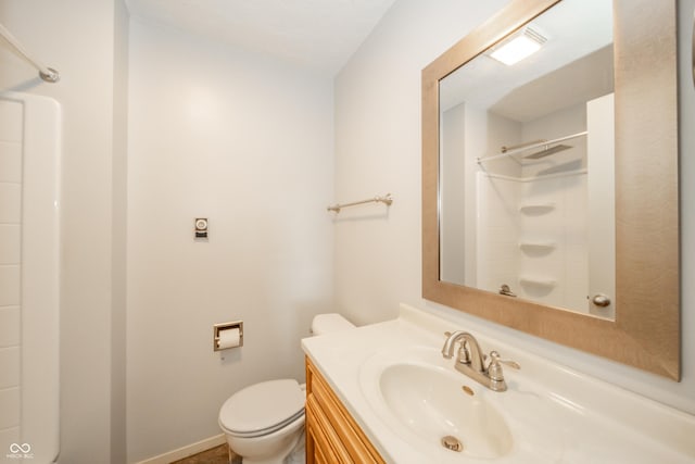 bathroom with vanity, toilet, and a shower