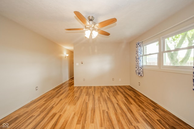 unfurnished room featuring light wood-type flooring, baseboards, and a ceiling fan