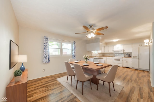 dining room featuring ceiling fan, baseboards, and light wood-style floors
