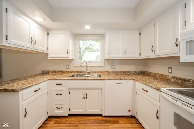 kitchen featuring a sink, white cabinets, white appliances, light wood-style floors, and recessed lighting