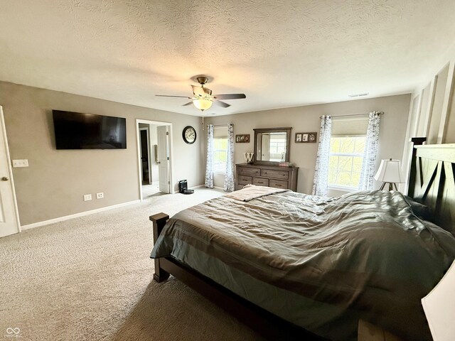 bedroom with carpet flooring, baseboards, a ceiling fan, and multiple windows