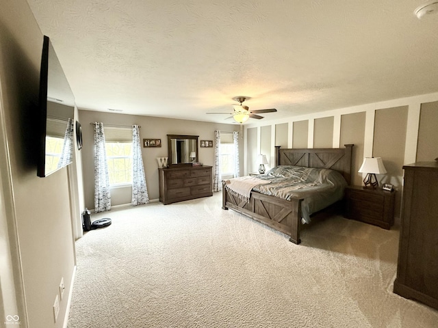 bedroom with carpet, a textured ceiling, and a ceiling fan