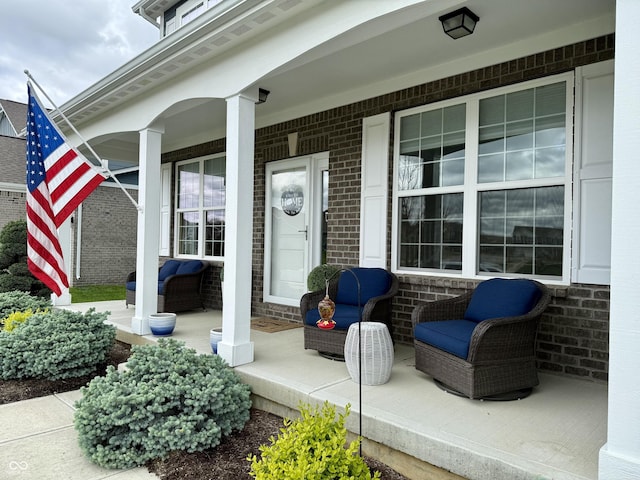 entrance to property with covered porch and brick siding