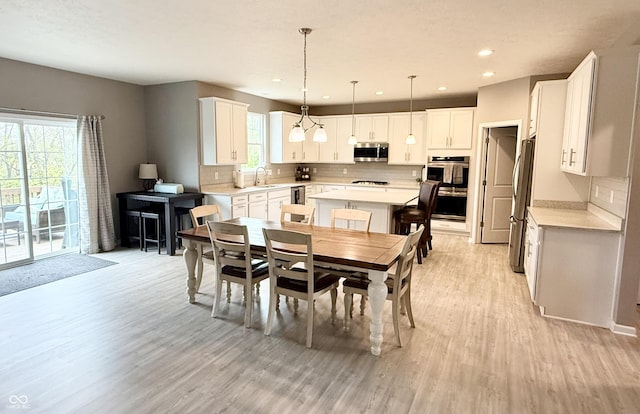 dining space featuring light wood finished floors and recessed lighting
