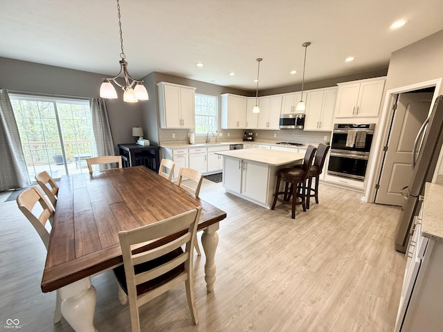 dining area featuring an inviting chandelier, recessed lighting, and light wood-style floors