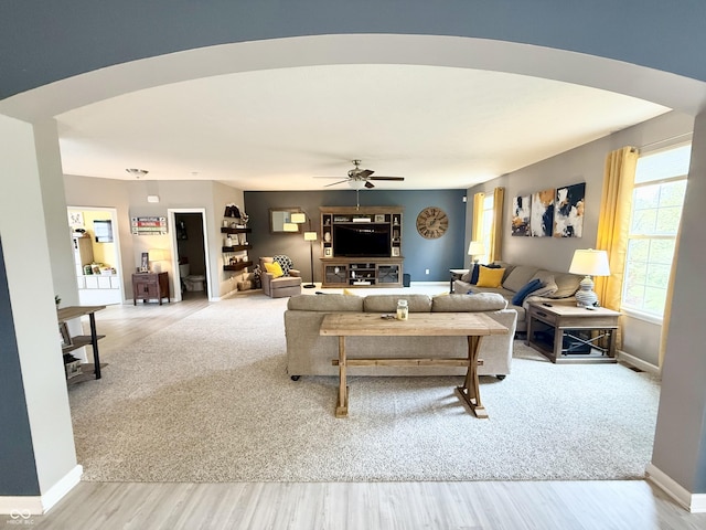 living area with a ceiling fan, wood finished floors, and baseboards