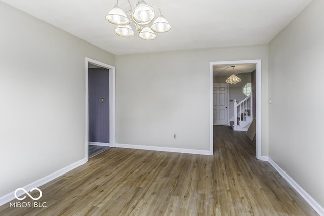 3134 W Hickory Woods Dr, Greenfield, IN 46140 - unfurnished dining area with a chandelier, wood finished floors, stairs, and baseboards
