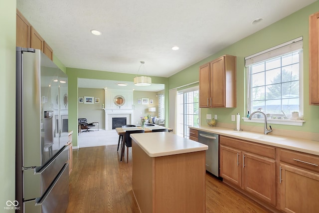 6839 Powder Dr, Indianapolis, IN 46259 - kitchen with appliances with stainless steel finishes, a sink, a center island, light countertops, and dark wood-style flooring