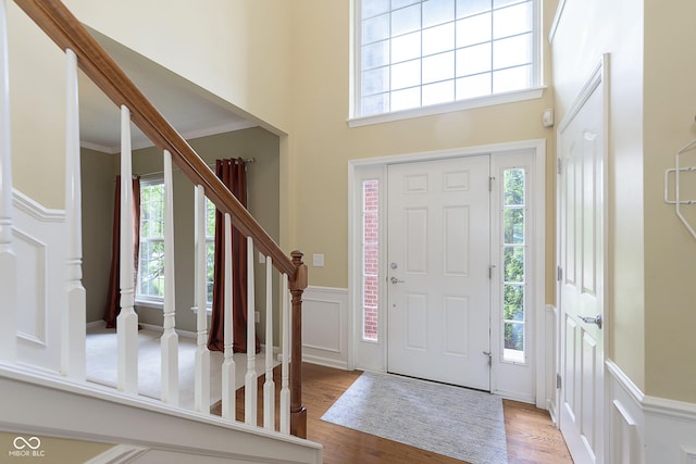 6839 Powder Dr, Indianapolis, IN 46259 - foyer featuring wood finished floors, plenty of natural light, stairs, wainscoting, and a towering ceiling