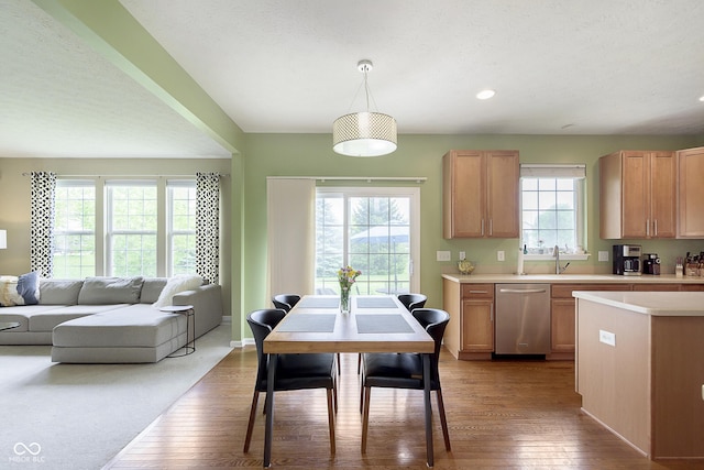 6839 Powder Dr, Indianapolis, IN 46259 - kitchen with stainless steel dishwasher, wood finished floors, light countertops, hanging light fixtures, and recessed lighting
