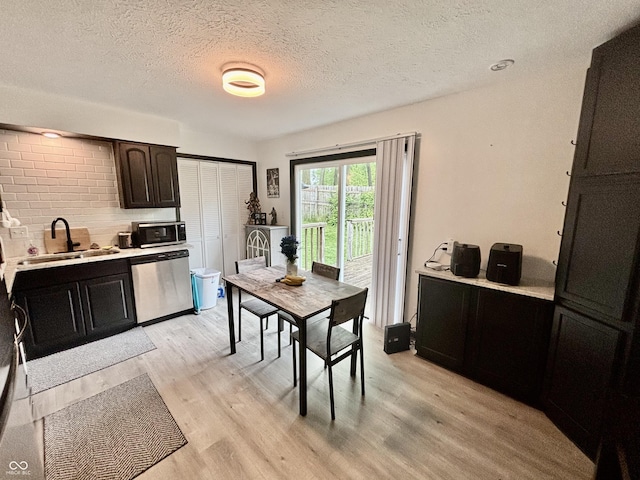kitchen with light countertops, stainless steel appliances, light wood-style flooring, and a sink