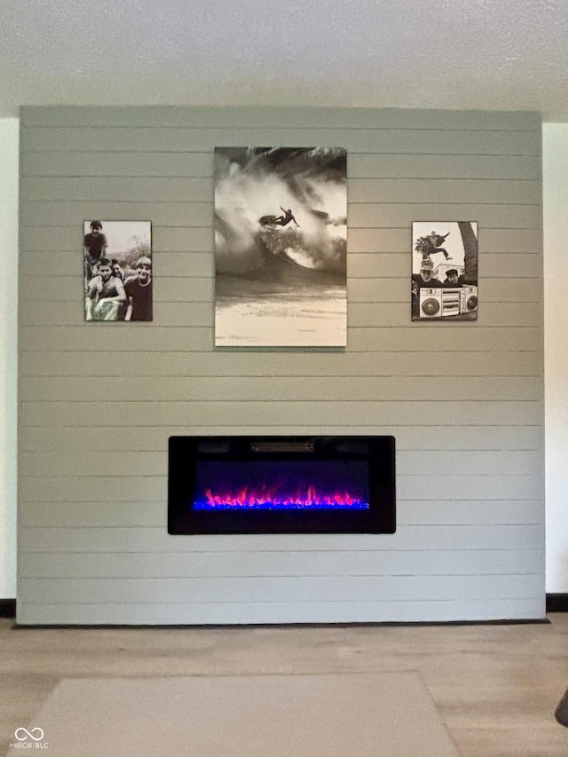 room details featuring a textured ceiling and a glass covered fireplace