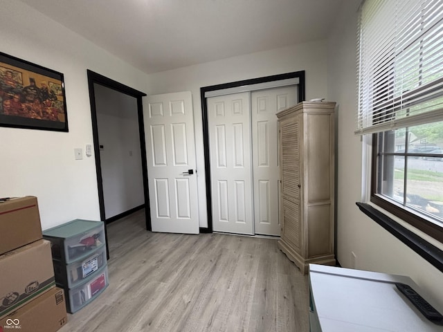 unfurnished bedroom featuring light wood finished floors and a closet