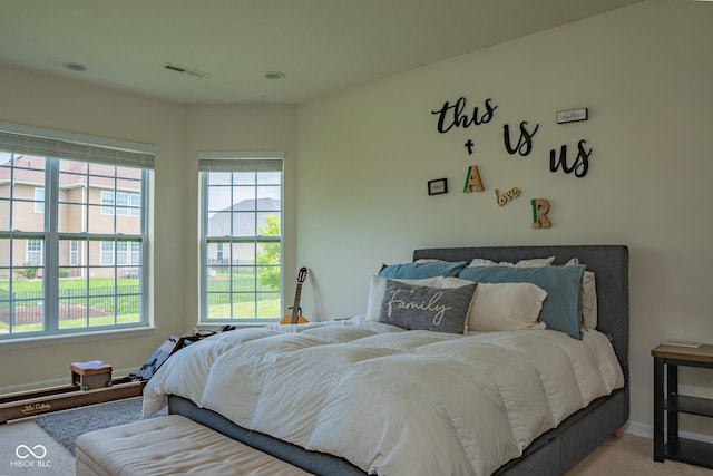 carpeted bedroom featuring multiple windows