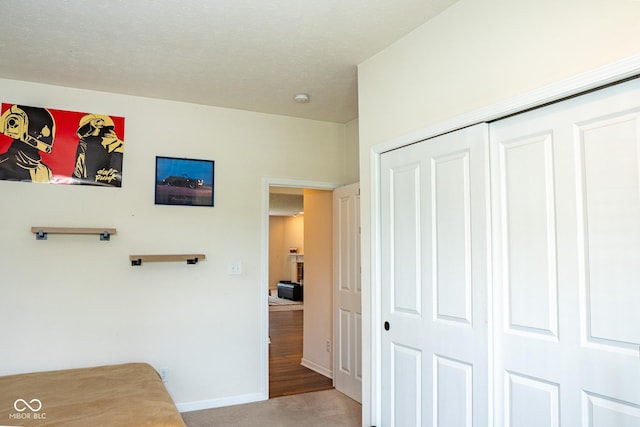 corridor featuring baseboards and light colored carpet