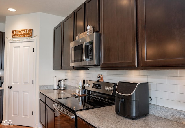 kitchen featuring stainless steel appliances, dark brown cabinetry, recessed lighting, backsplash, and light stone counters