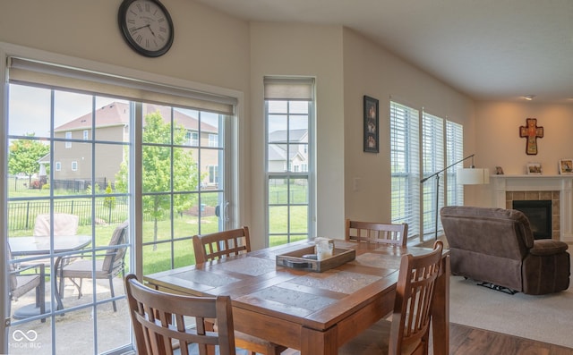 dining space featuring wood finished floors and a tile fireplace
