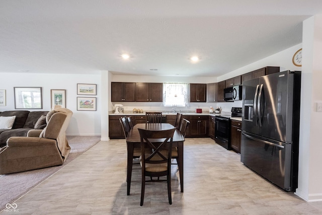 509 Tulip Tree Dr, Lapel, IN 46051 - kitchen featuring black appliances, dark brown cabinets, open floor plan, light countertops, and a sink