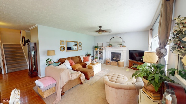 18247 Kinder Oak Dr, Noblesville, IN 46062 - living area featuring stairway, a ceiling fan, a fireplace, wood finished floors, and a textured ceiling