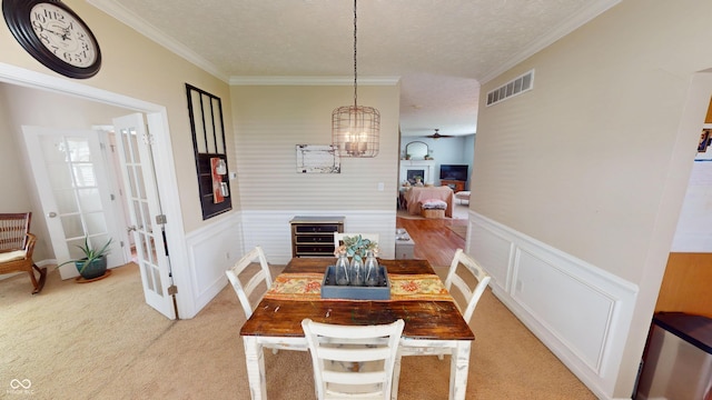 18247 Kinder Oak Dr, Noblesville, IN 46062 - dining area featuring light carpet, wainscoting, ornamental molding, a textured ceiling, and a chandelier