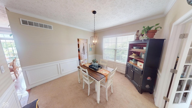 18247 Kinder Oak Dr, Noblesville, IN 46062 - dining space with a textured ceiling, a chandelier, light colored carpet, crown molding, and wainscoting