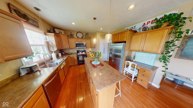18247 Kinder Oak Dr, Noblesville, IN 46062 - kitchen featuring appliances with stainless steel finishes, a sink, a center island, light wood-style floors, and recessed lighting