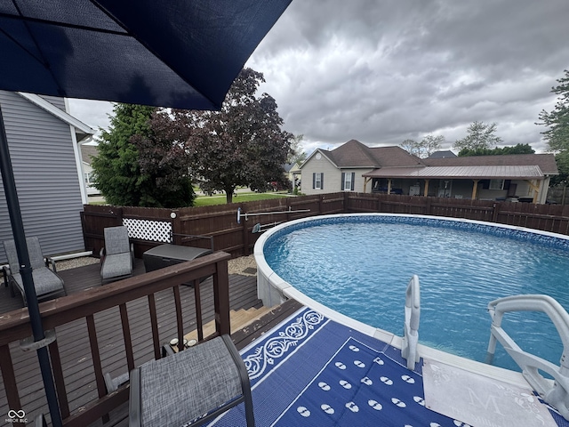 view of swimming pool with a fenced backyard and a wooden deck