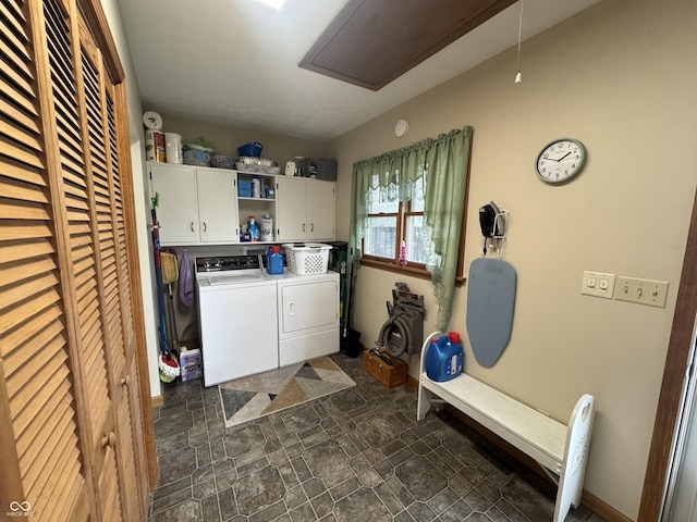 clothes washing area featuring attic access, cabinet space, separate washer and dryer, and stone finish flooring