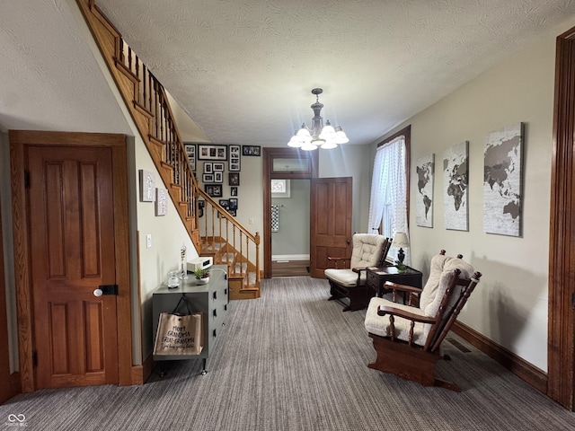 living area featuring carpet floors, a chandelier, stairway, baseboards, and a textured ceiling