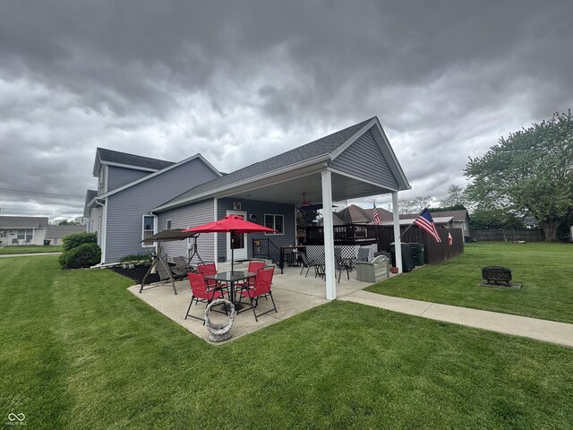rear view of house featuring a fire pit and a patio