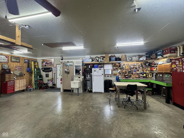 garage with a workshop area and freestanding refrigerator
