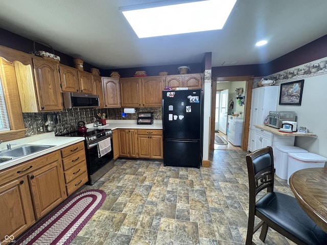 kitchen with appliances with stainless steel finishes, light countertops, tasteful backsplash, a sink, and brown cabinets