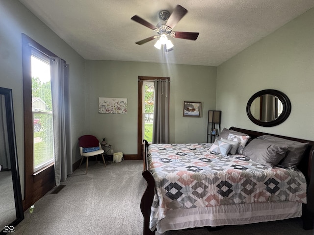 carpeted bedroom featuring a textured ceiling, a ceiling fan, and baseboards