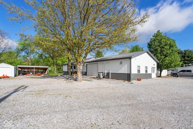 view of front facade featuring an attached garage, an outbuilding, and driveway