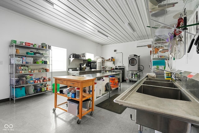 kitchen featuring a sink, an AC wall unit, and tile patterned floors