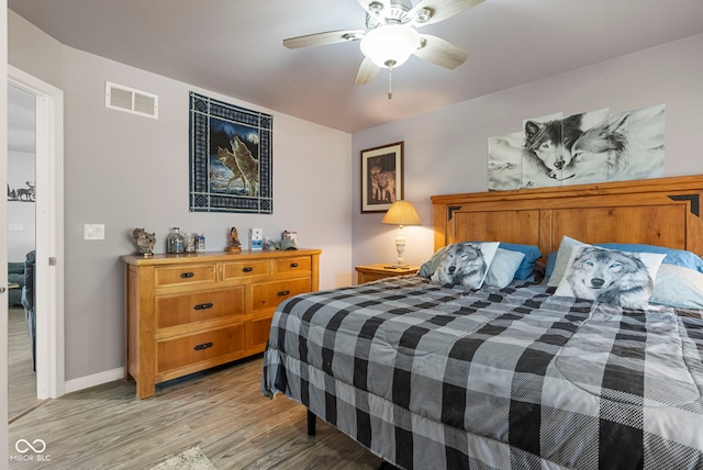 bedroom with a ceiling fan, visible vents, light wood-style flooring, and baseboards