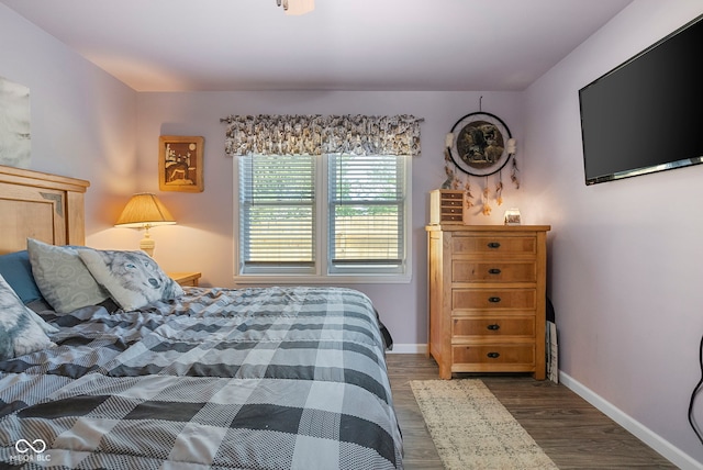 bedroom with dark wood-style flooring and baseboards