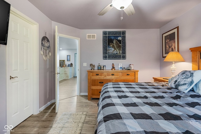 bedroom with baseboards, visible vents, a ceiling fan, and wood finished floors