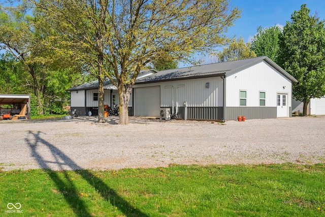view of outdoor structure with ac unit, driveway, and an attached garage