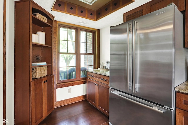 6505 Miramar Ct, Indianapolis, IN 46250 - kitchen with freestanding refrigerator, dark wood-style floors, light stone countertops, baseboards, and brown cabinets