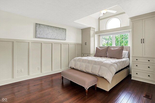 6505 Miramar Ct, Indianapolis, IN 46250 - bedroom featuring a decorative wall, dark wood-type flooring, wainscoting, and vaulted ceiling