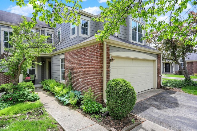 6505 Miramar Ct, Indianapolis, IN 46250 - view of property exterior featuring a garage, driveway, and brick siding