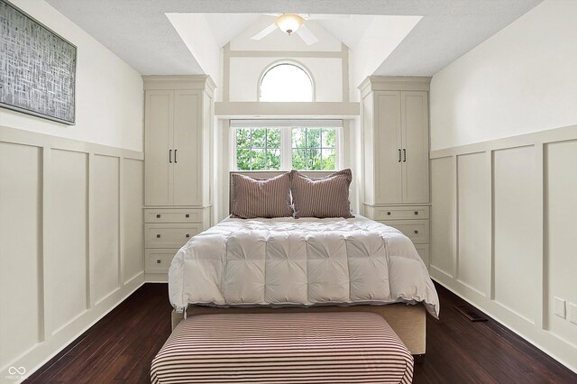 6505 Miramar Ct, Indianapolis, IN 46250 - bedroom with a decorative wall, dark wood-style floors, lofted ceiling, wainscoting, and ceiling fan