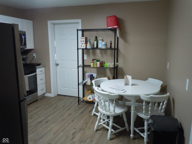 dining area featuring baseboards and light wood-style floors