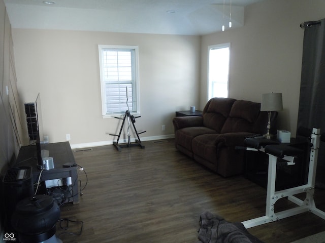 living area featuring visible vents, baseboards, plenty of natural light, and wood finished floors