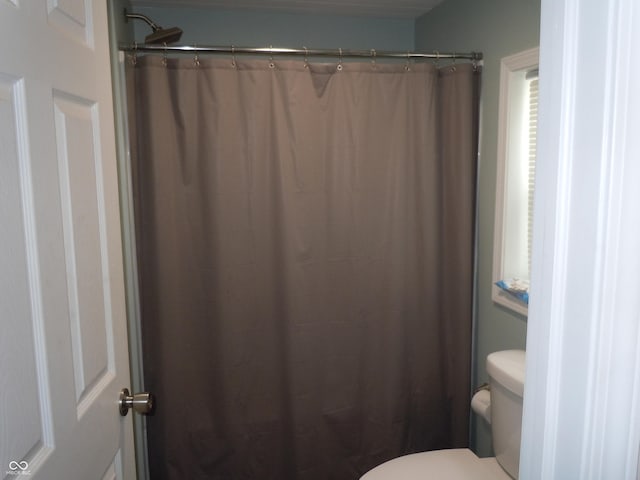 bathroom featuring toilet and a shower with shower curtain