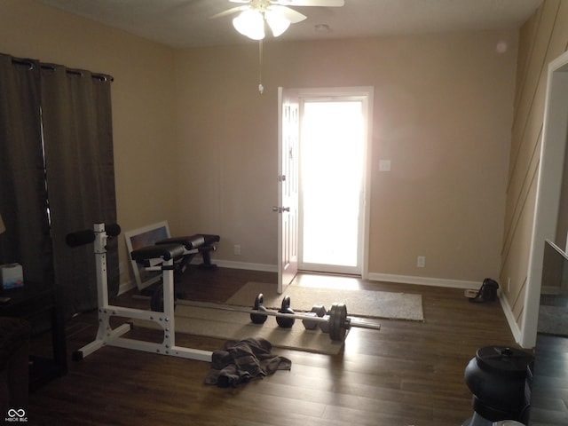 exercise area featuring wood finished floors, baseboards, and ceiling fan